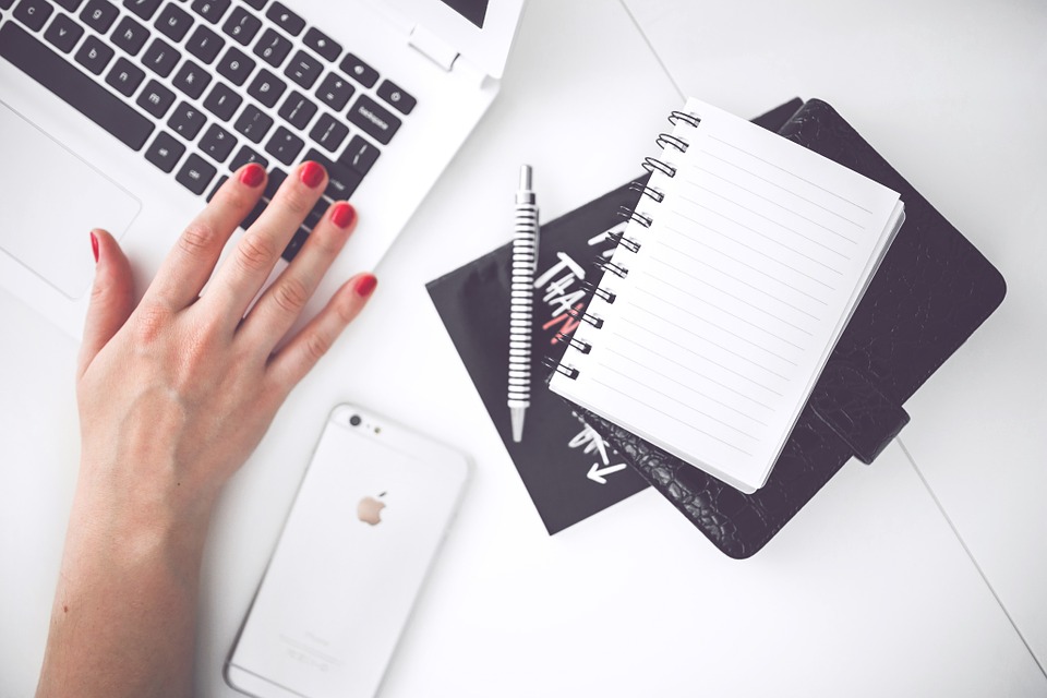 A desk flatlay with someone working on a macbook pro.