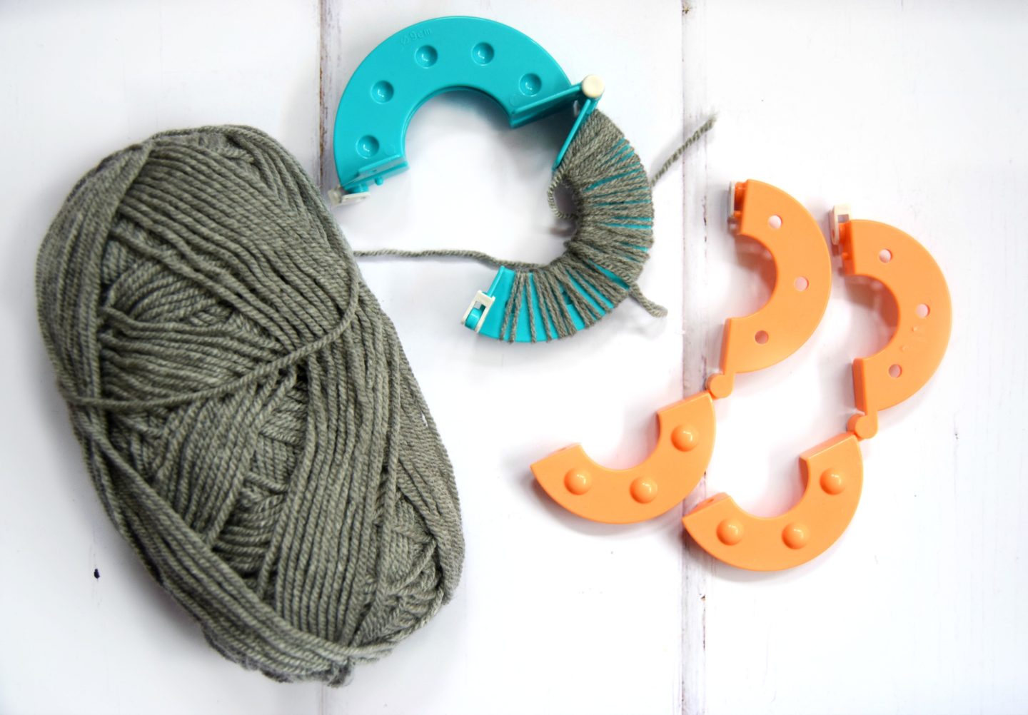Using grey yarn with a pom pom maker.