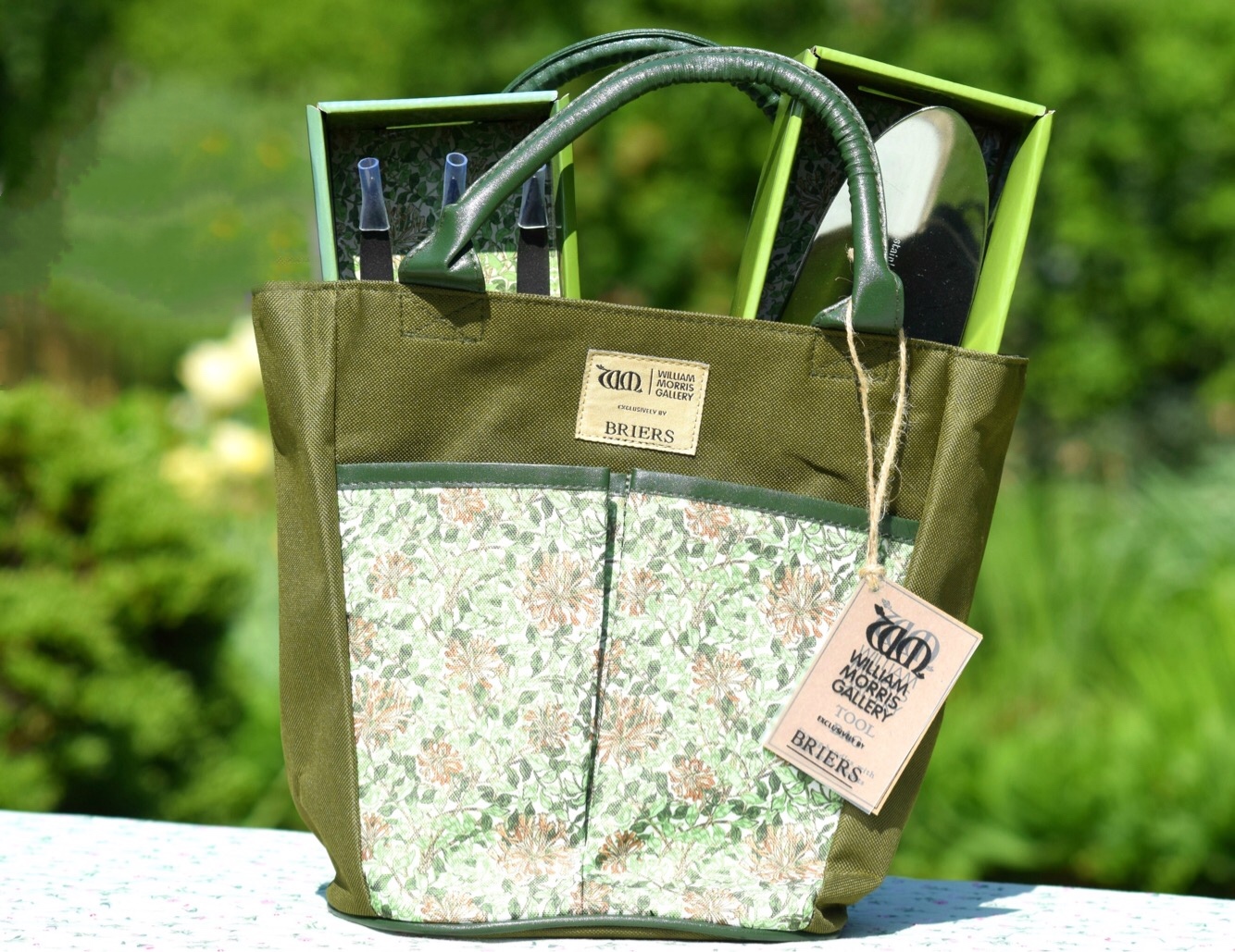 Gardening gift bag set. A pretty floral bag holding a trowel and fork.