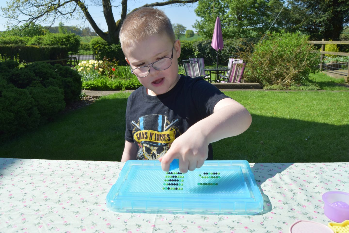 Spraying Aquabeads with water to make them set.
