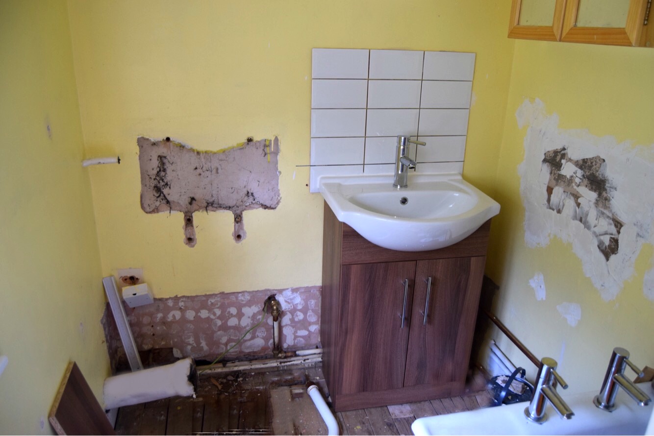 Installing basin unit in bathroom.