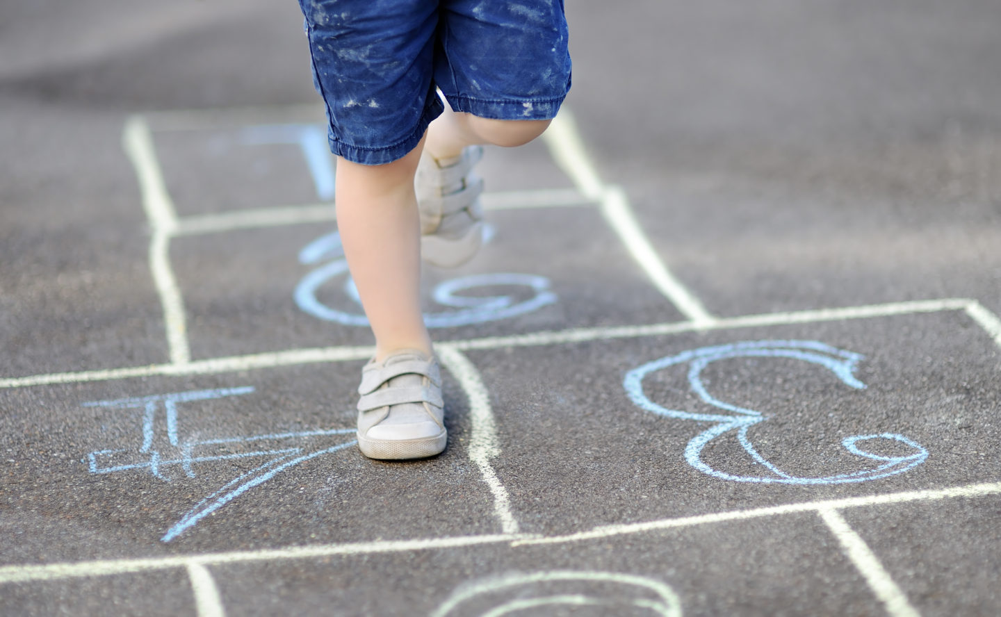 child playing hopscotch playground game