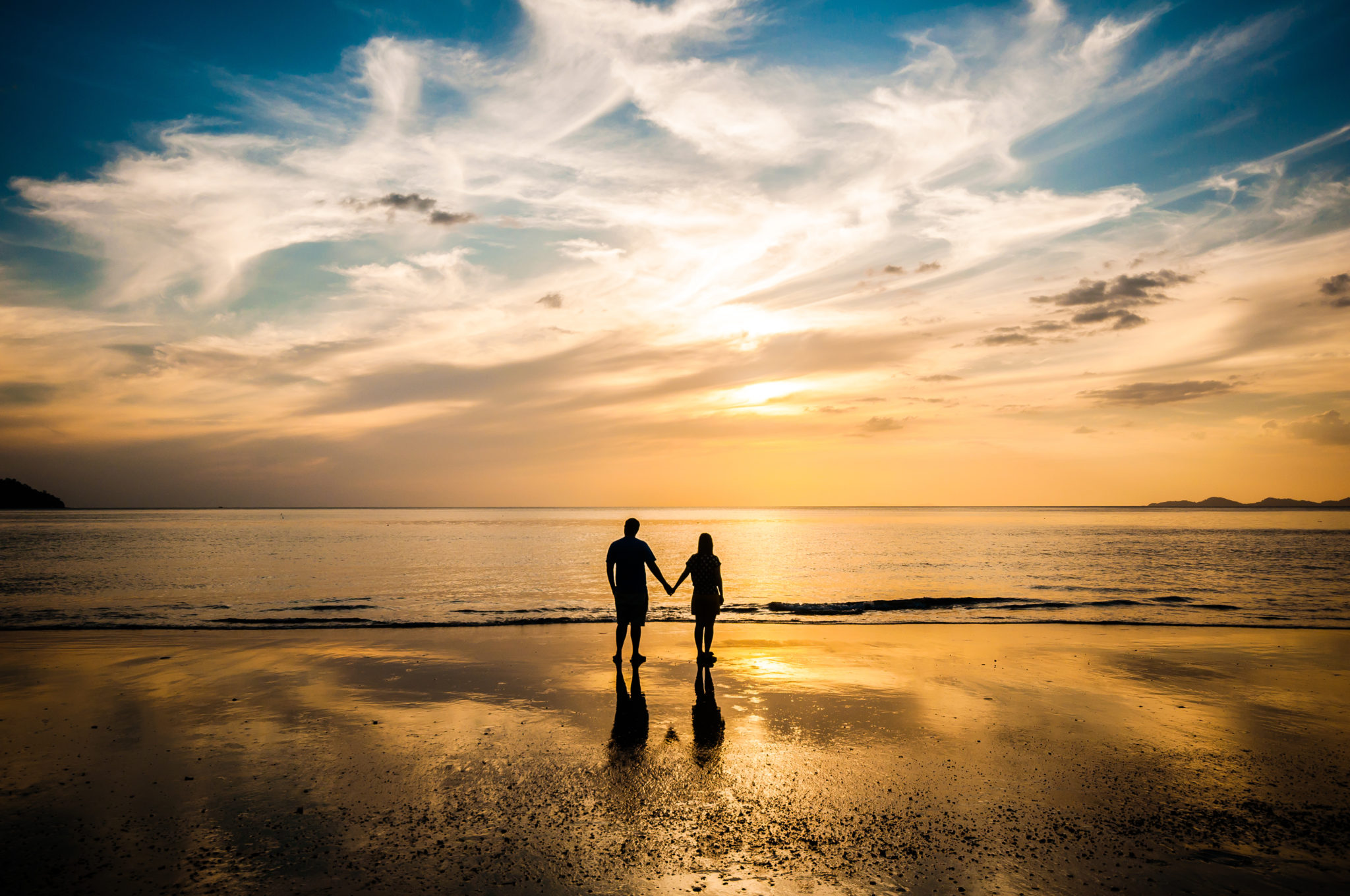Romantic getaways For Couples. A couple standing on the beach together.
