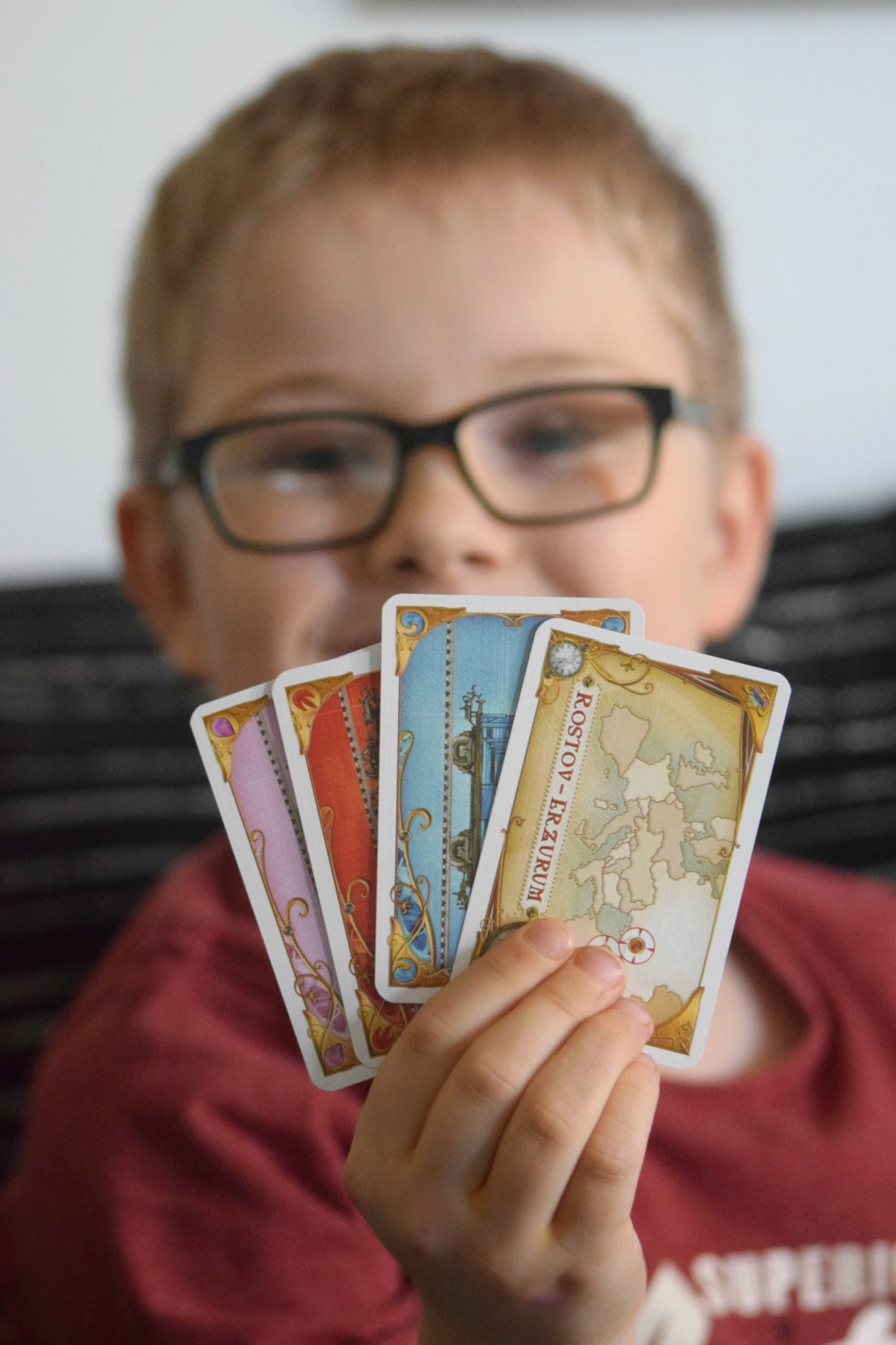 My son holding the playing cards for Ticket to ride Europe board game.