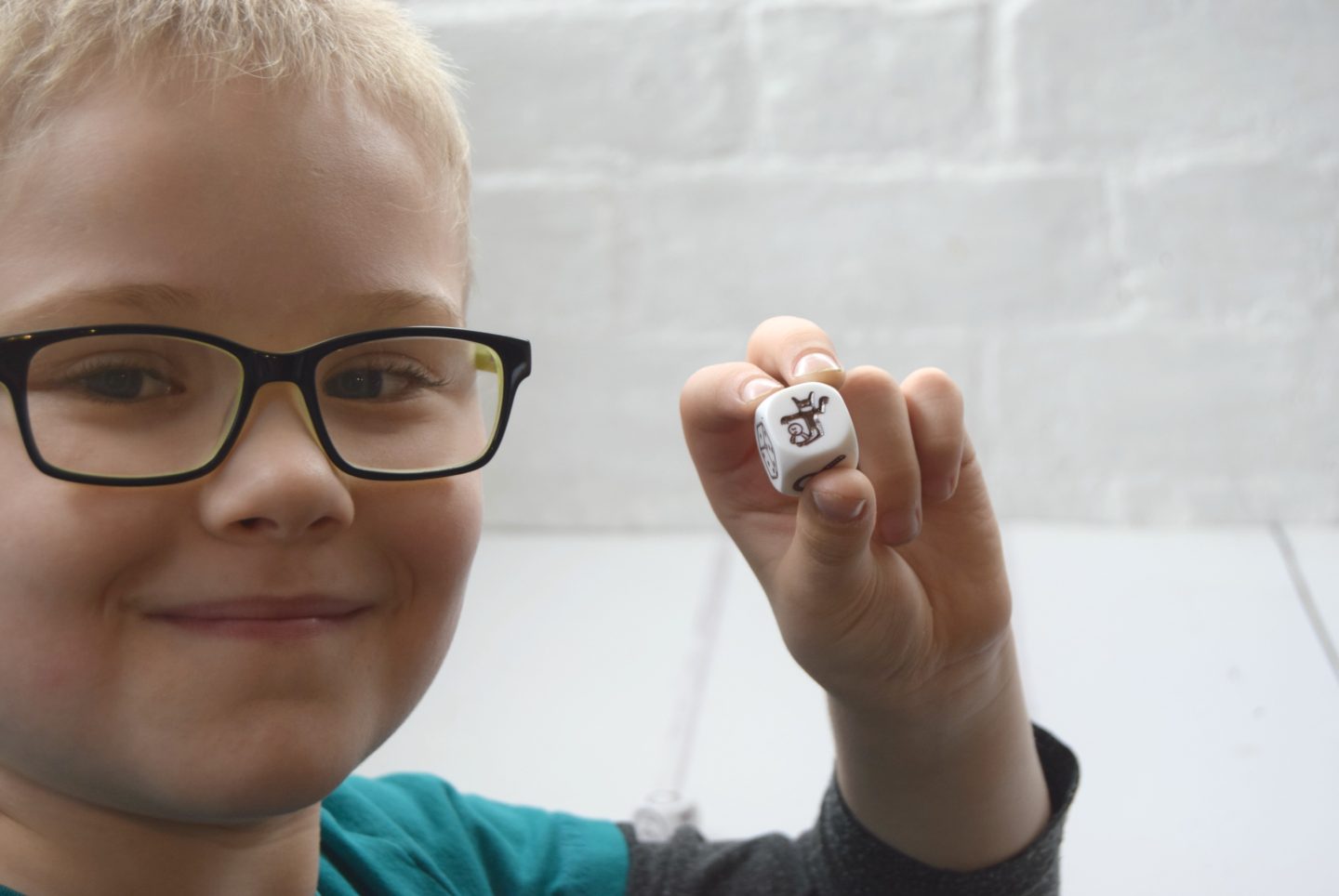 Rory's Story Cubes game. My son holding one of the 9 story dice used to make a story.