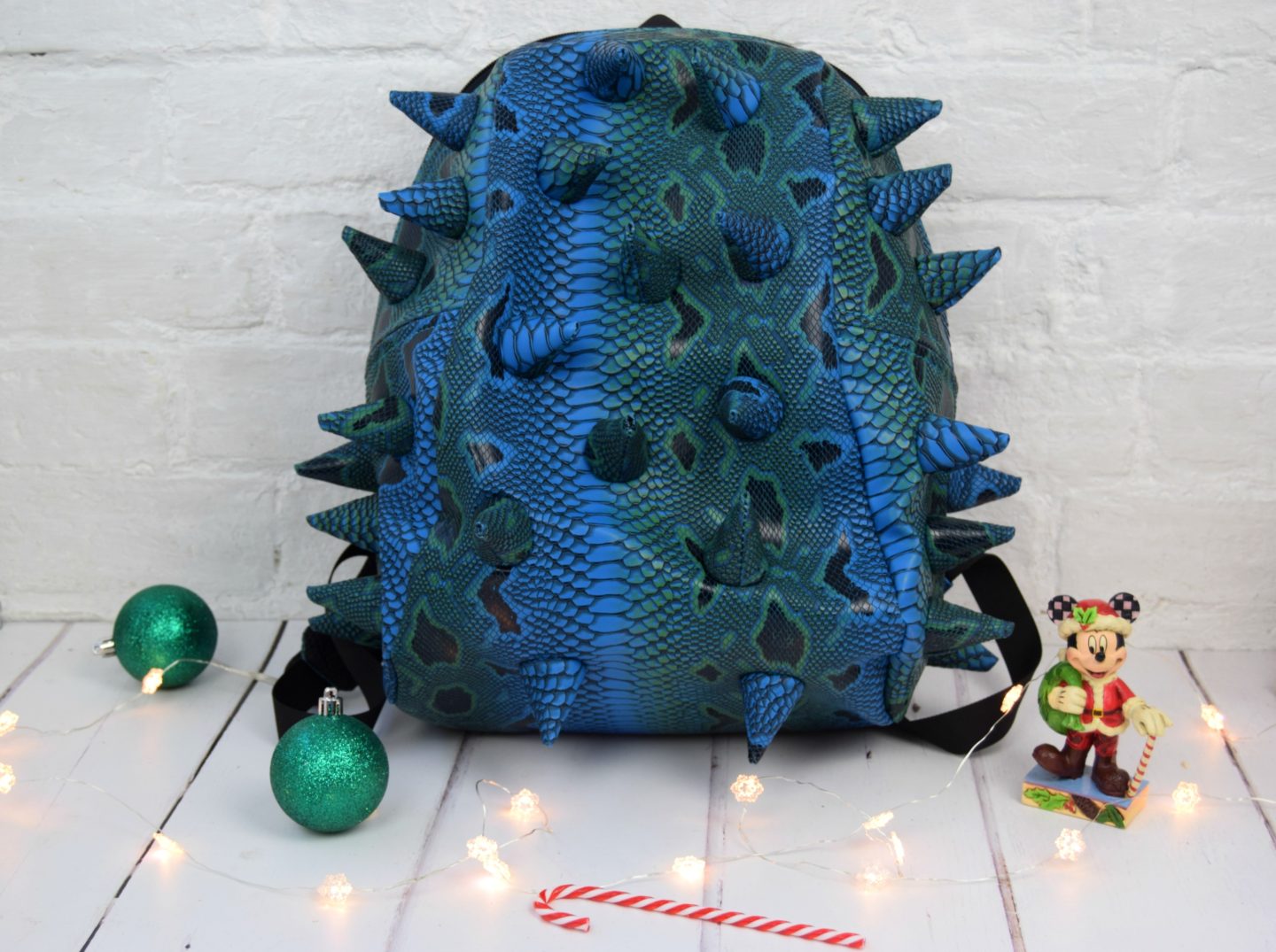 A blue Kids dinosaur bag with foam spikes on.