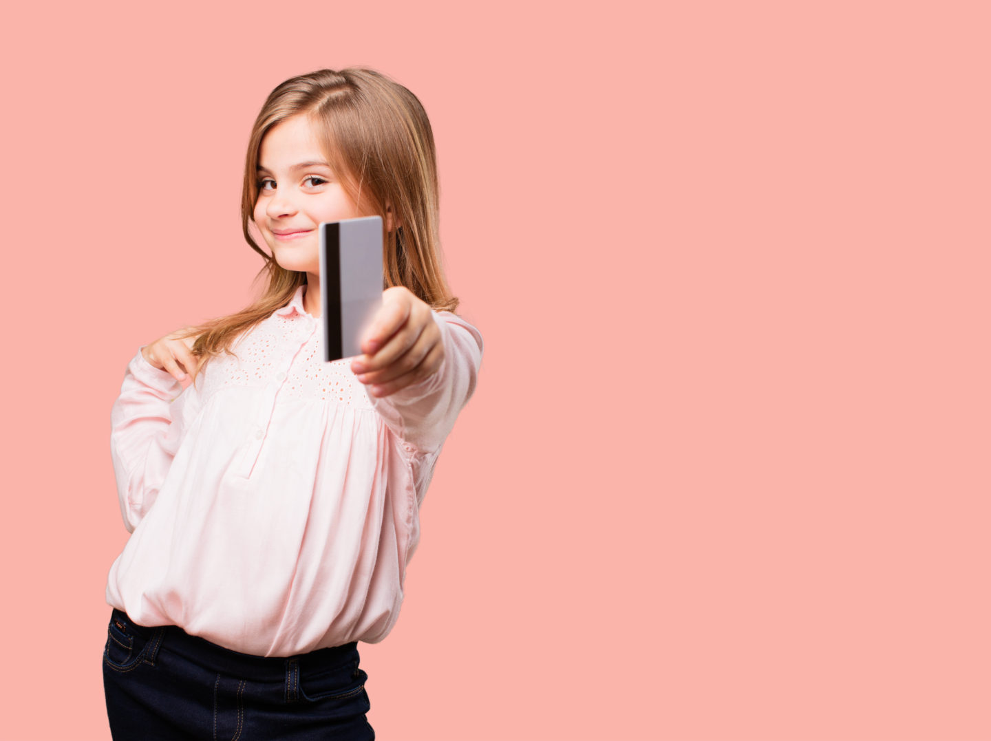 A little girl holding a bank card