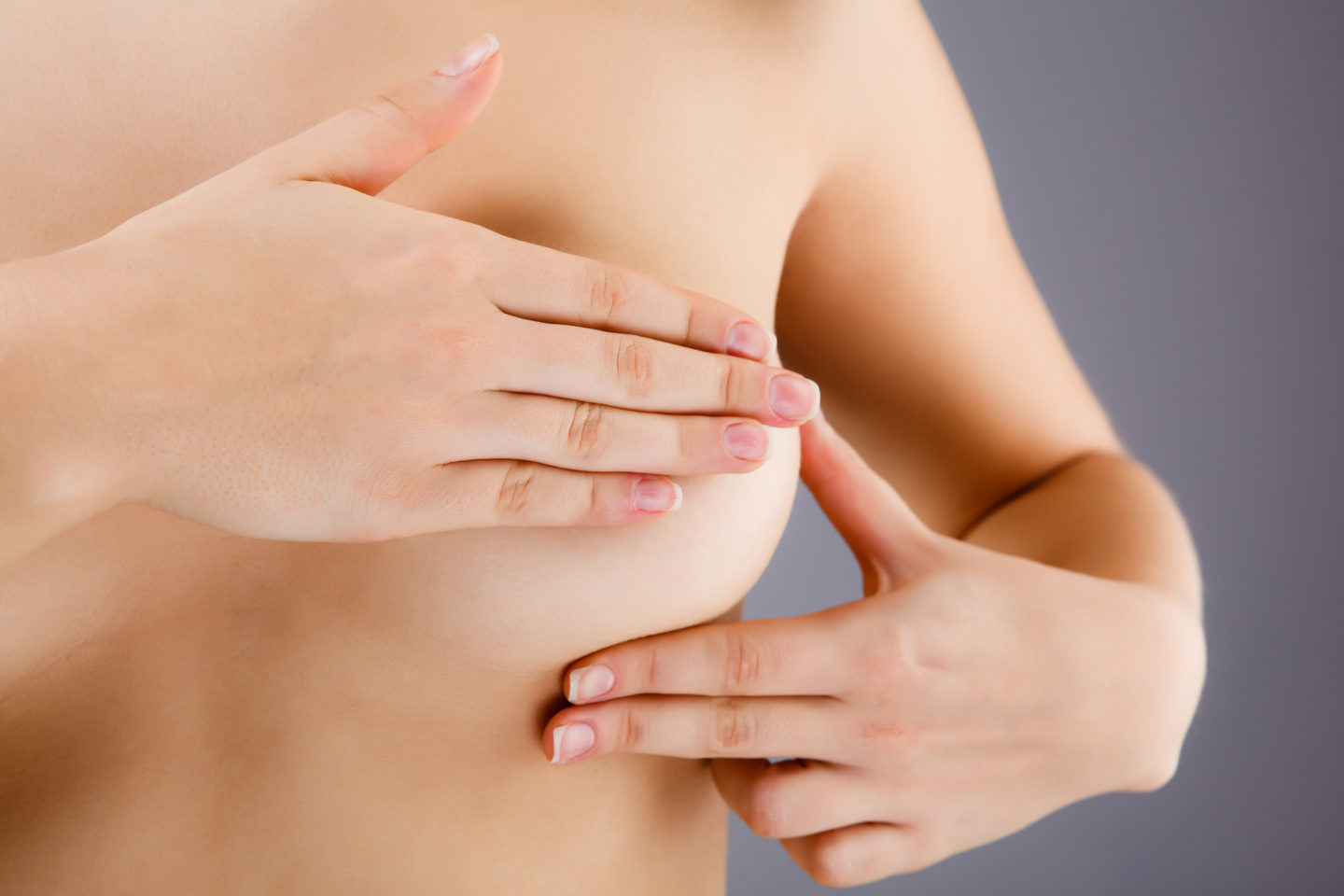 A lady self checking her breasts for lumps