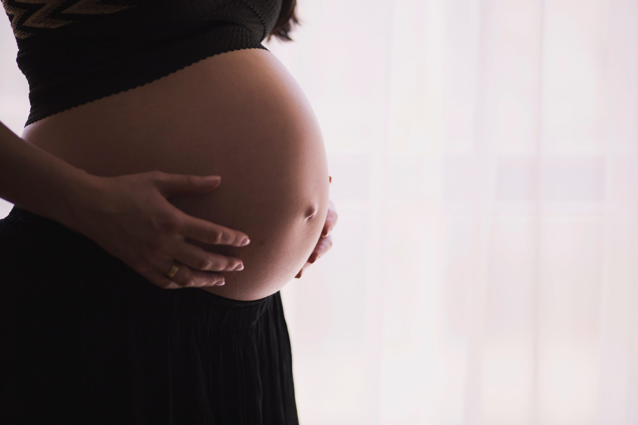 A pregnant lady holding her bump.