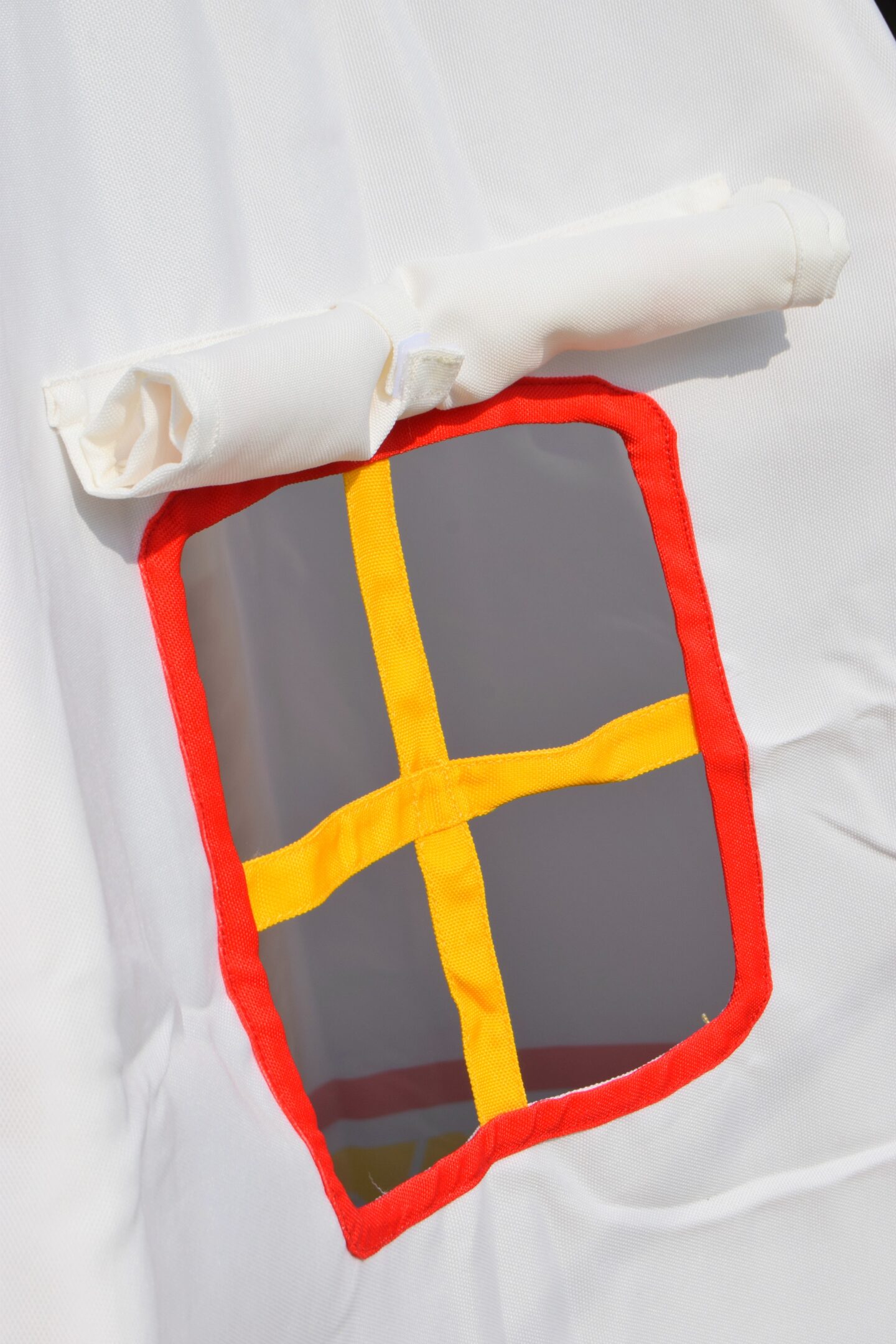 A pretty red and yellow window on the kids Hape canvas teepee. It laso has a little canvas shutter that folds down.