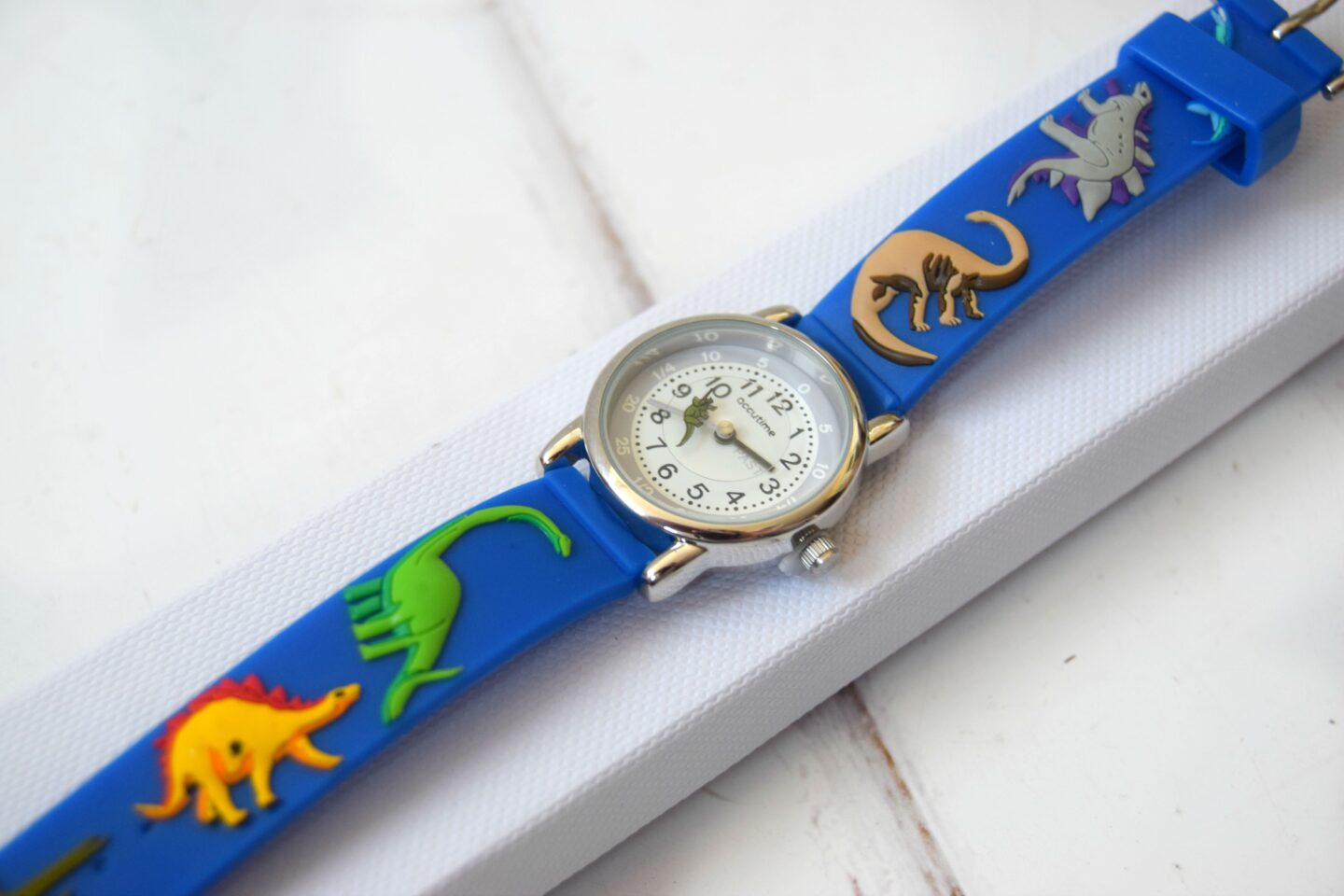 Children's Personalised watch with a blue strap and dinosaurs on.