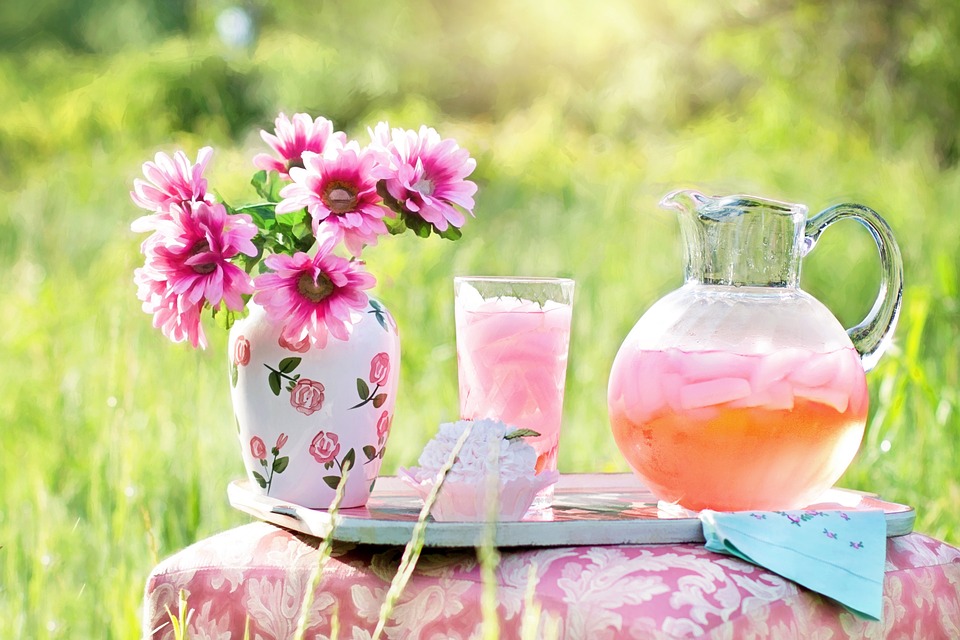 A jug of pink lemonade on a table outside