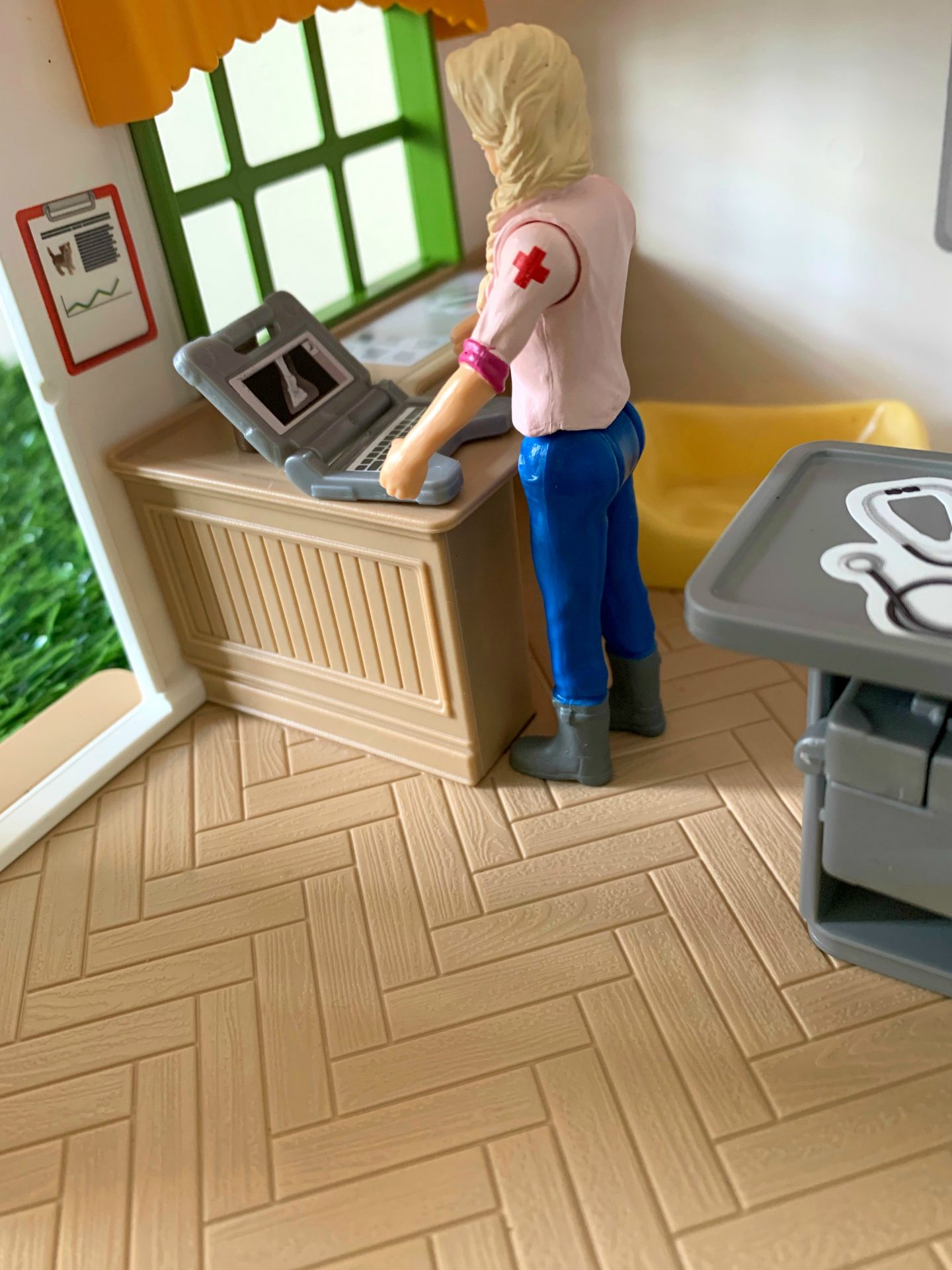 Schleich Farm World Vet figure using the surgery laptop