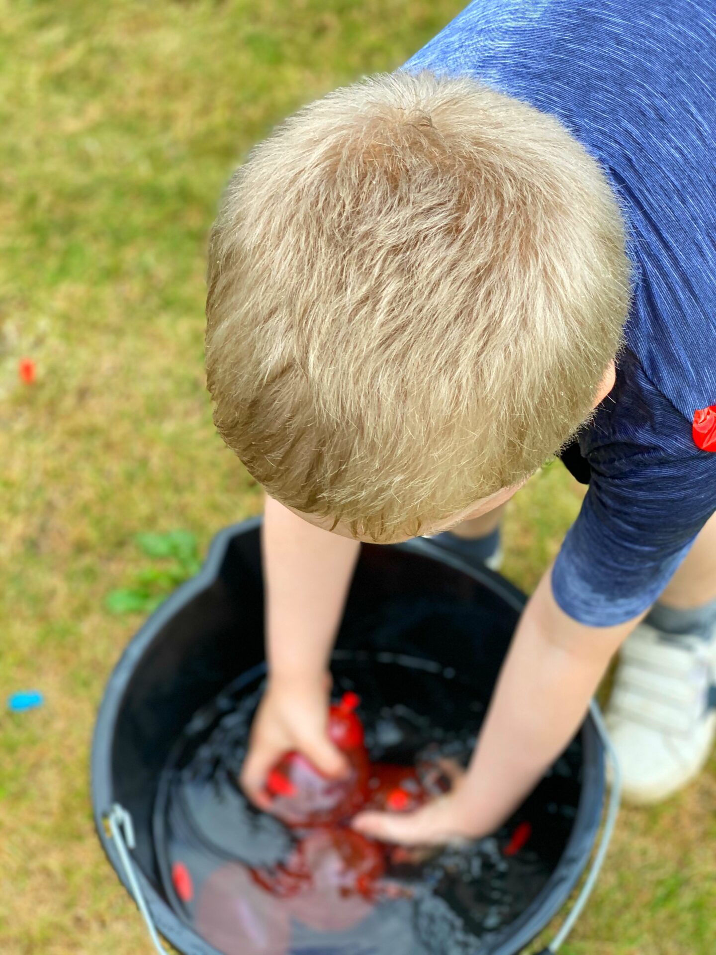 Getting water balloons from a bucket ready for a water fight.