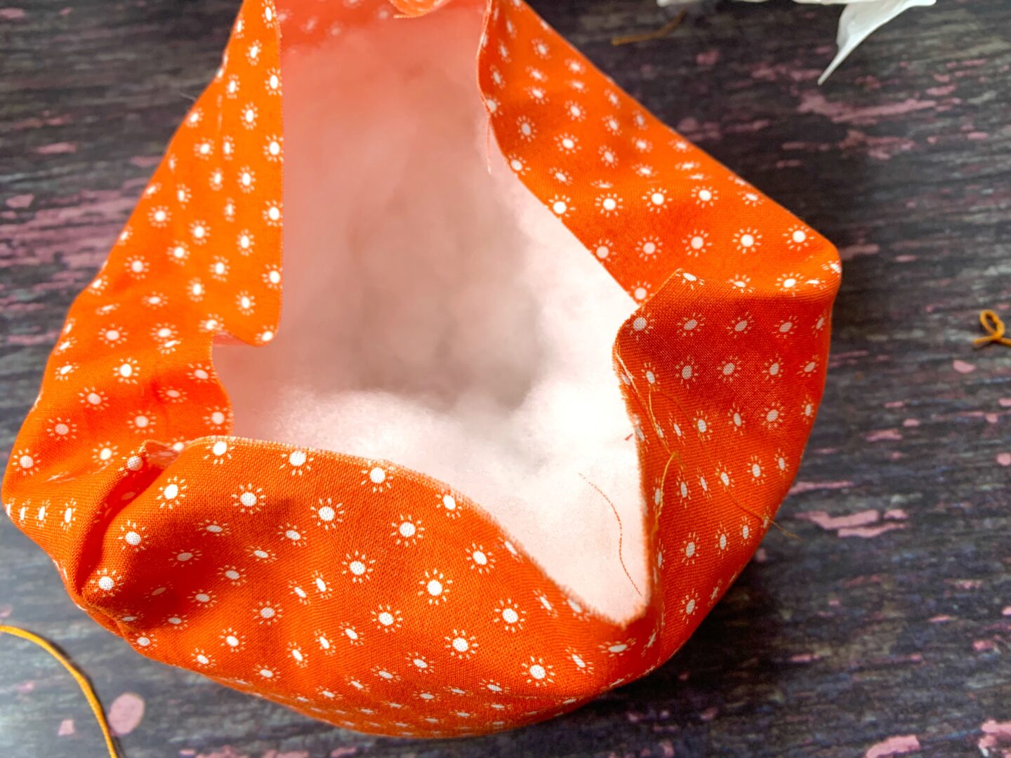 filling the fabric pumpkin with stuffing