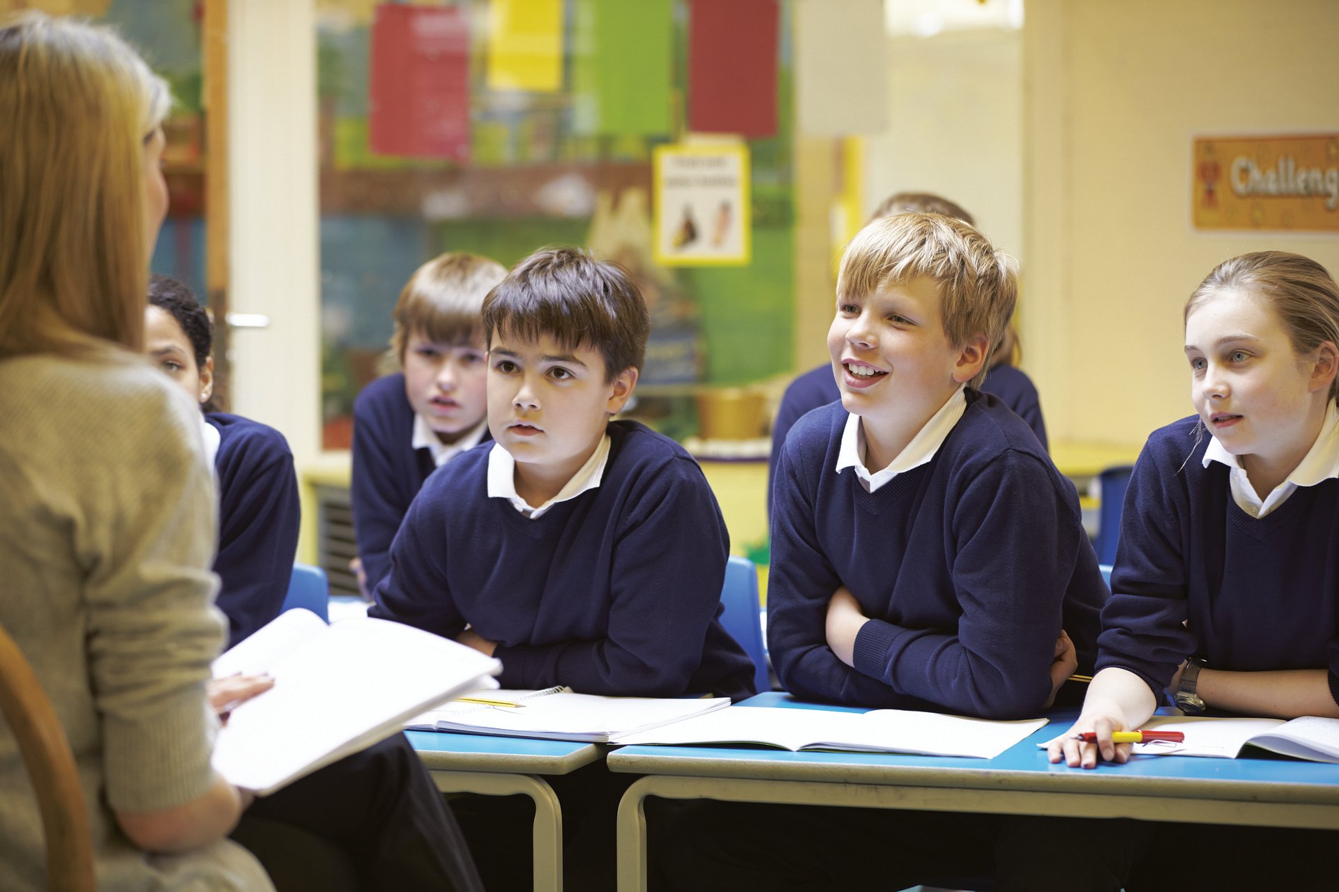 A teacher teaching primary school aged children in a classroom.