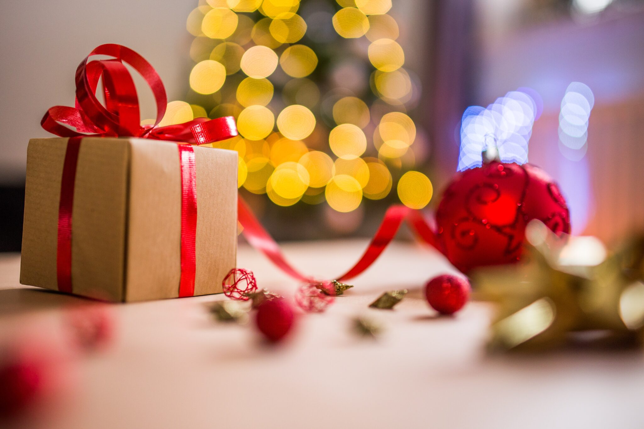 Christmas gifts wrapped in brown paper and finished with a satin red ribbon.