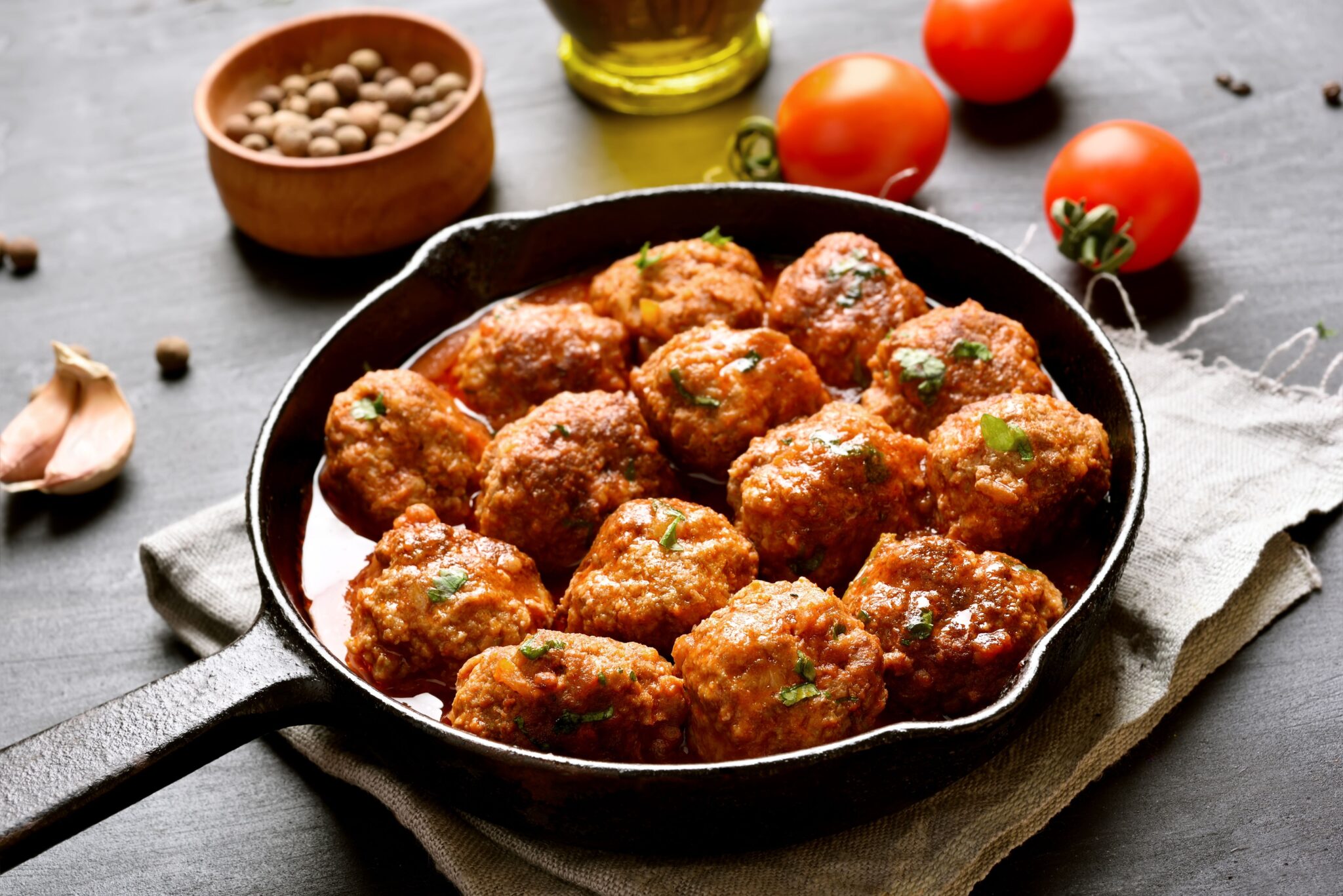 Super tasty Meatballs recipe. A pan of meatballs with some tomatoes on the side.