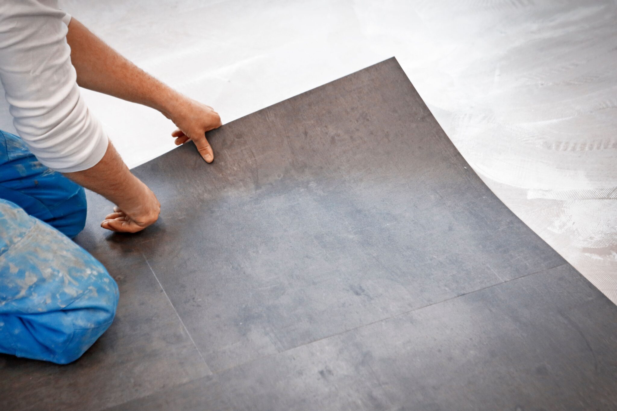 Vinyl flooring being laid by a man