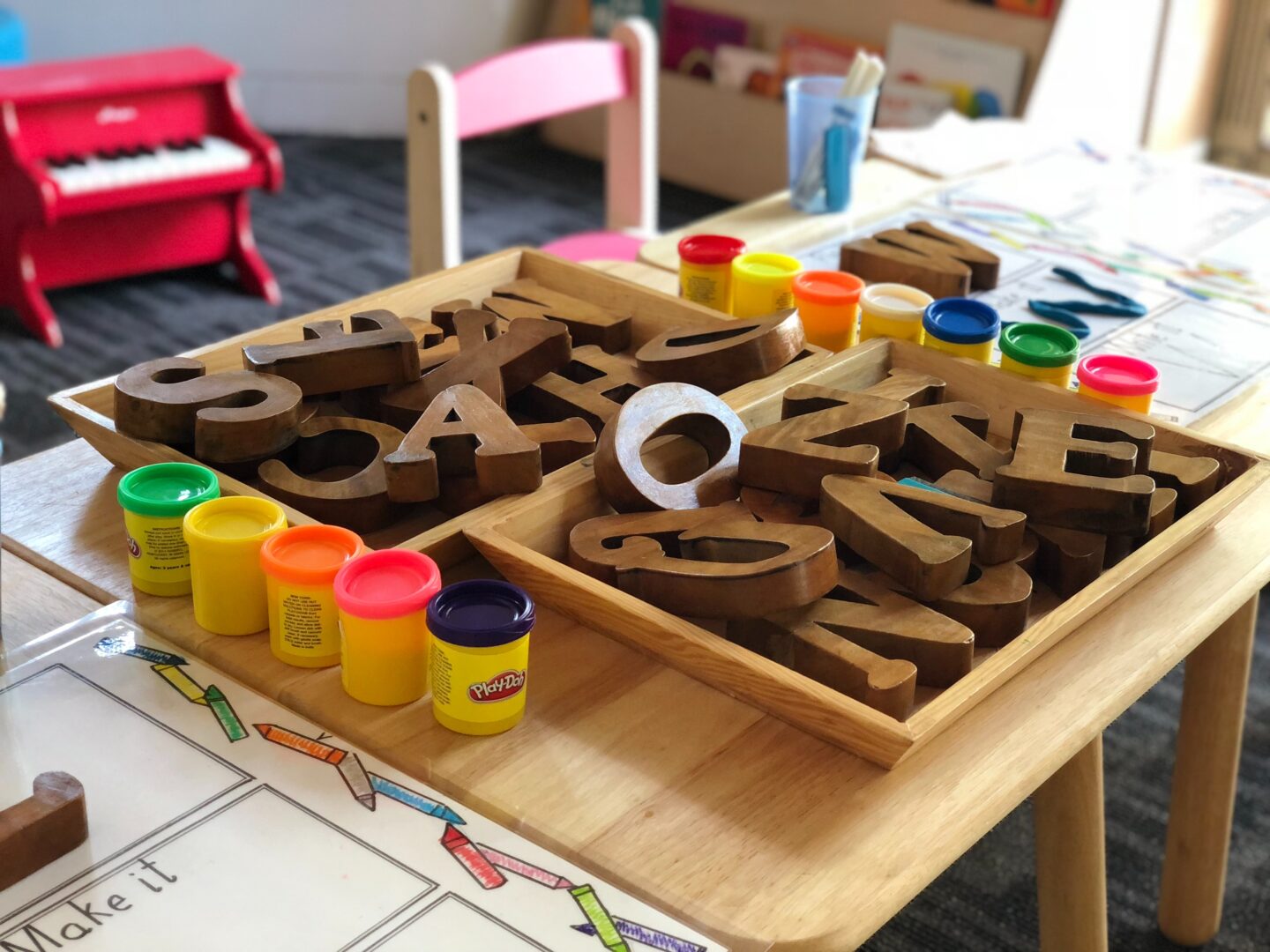A nursery school table with playdoh and learning accessories.