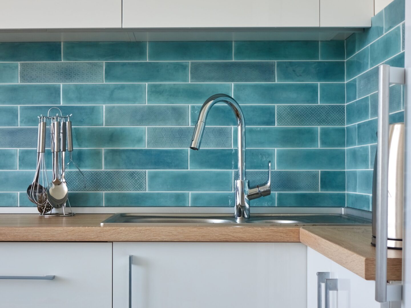 Modern kitchen with stylish teal colored brick style tiles