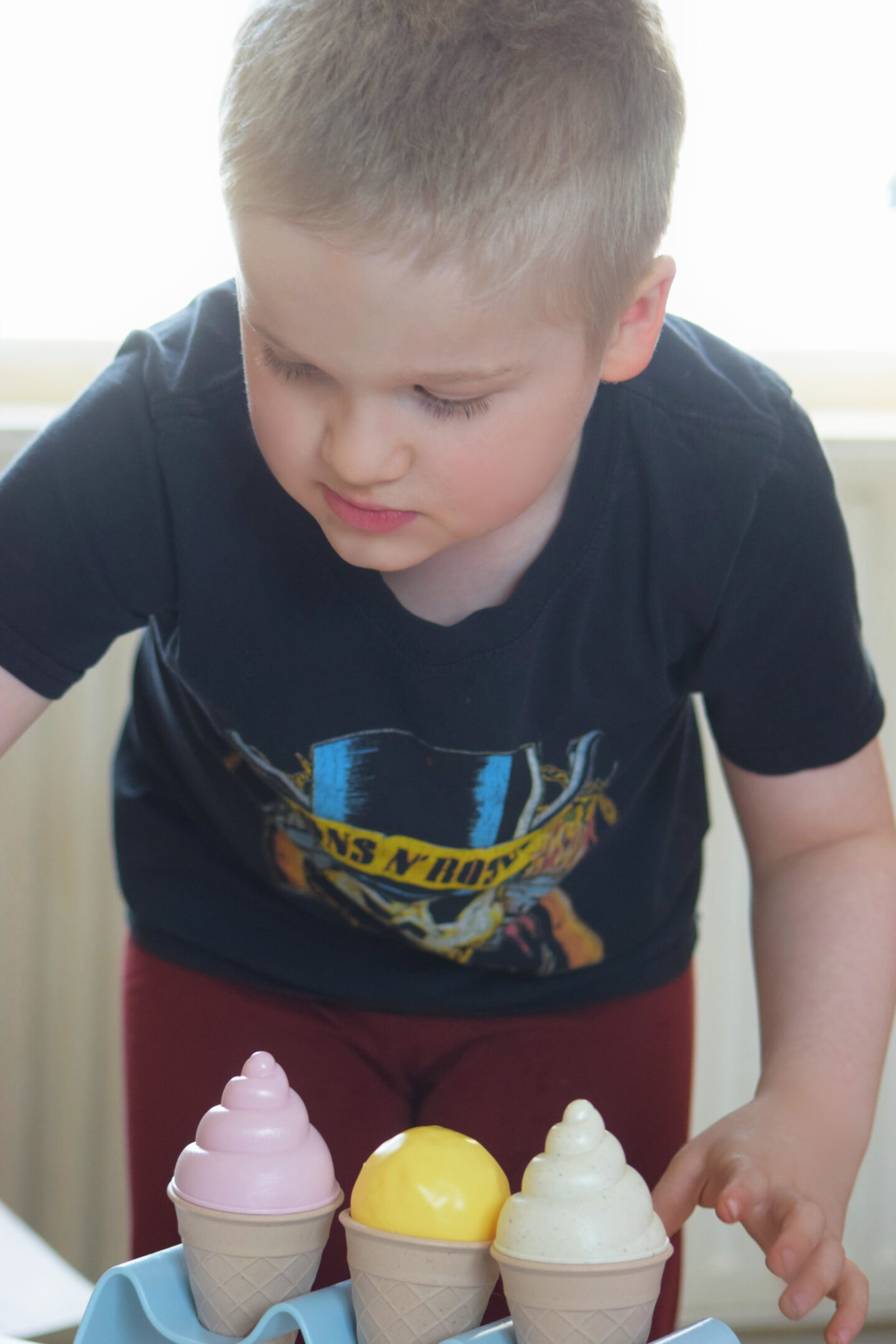 a boy playing with a pretend ice cream playset