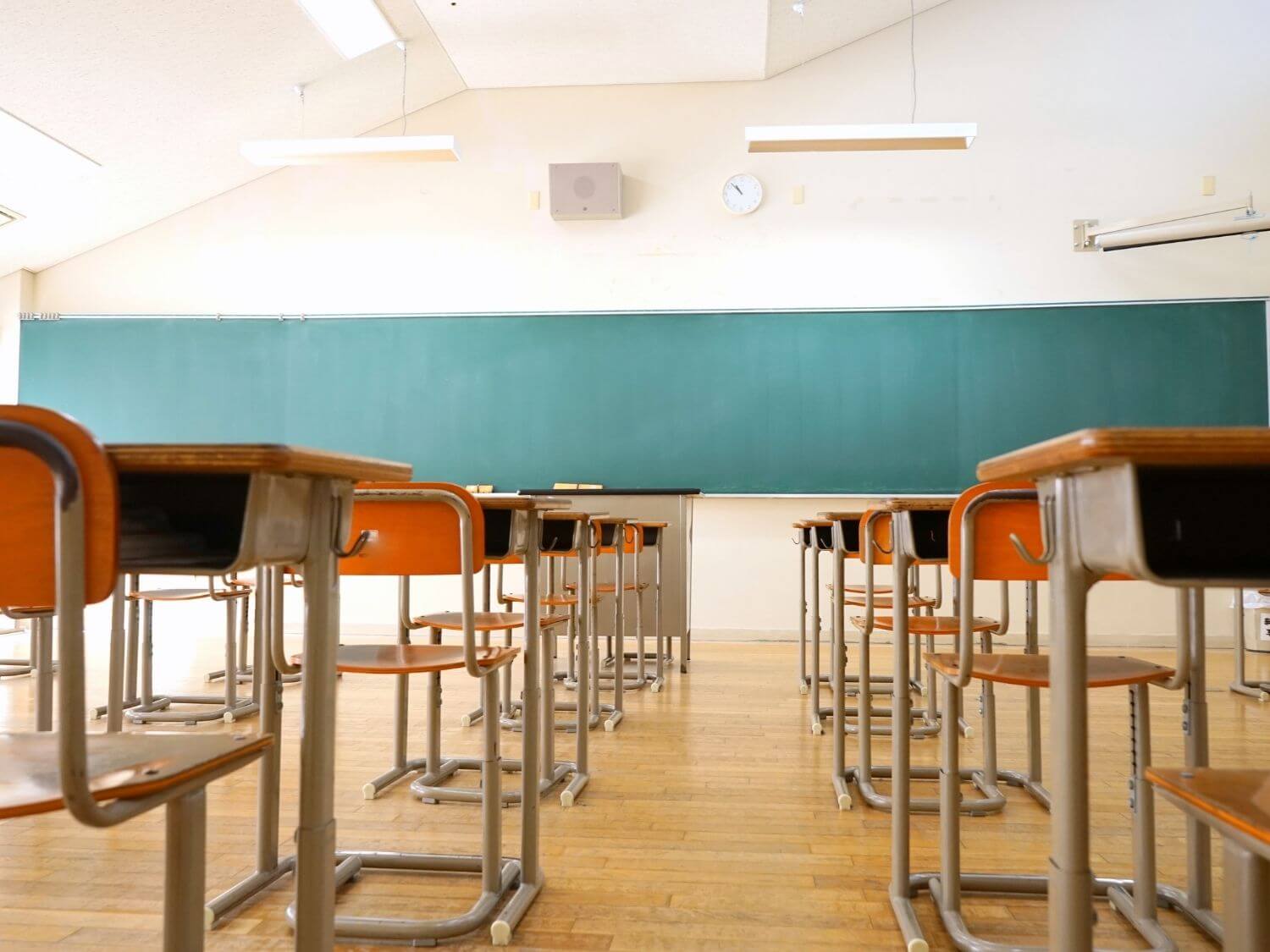 A school classroom with empty desks and chairs.