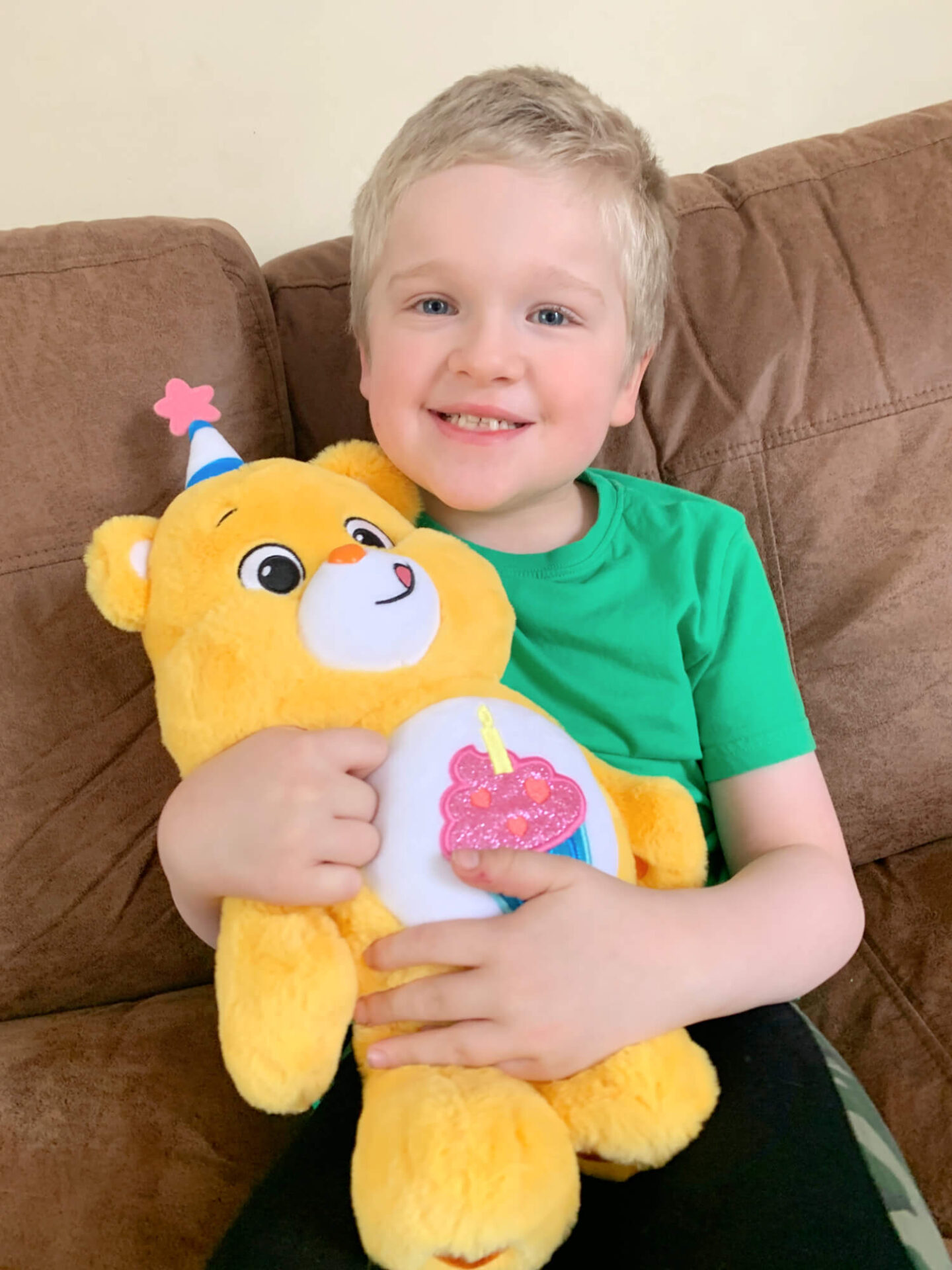 A boy holding a birthday care bear