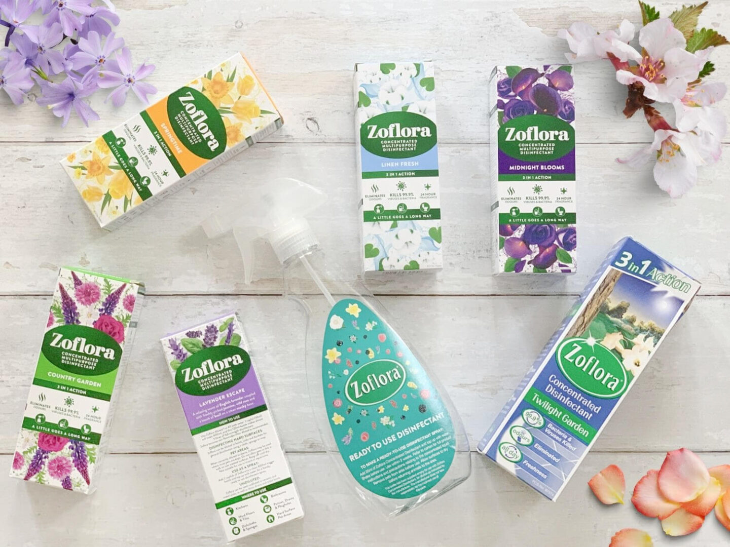 A selection of Zoflora disinfectant bottles and a trigger spray surrounded by flower petals