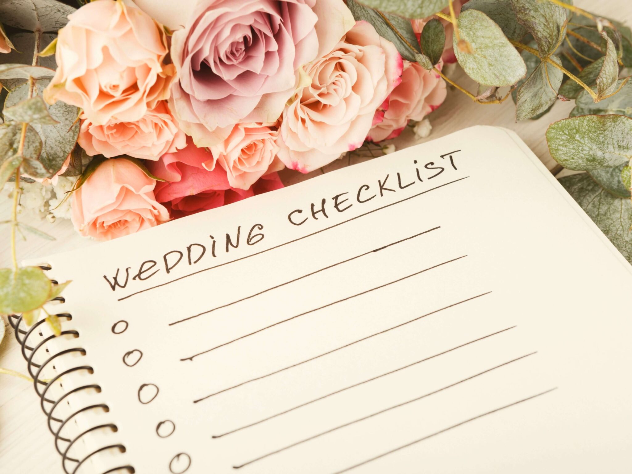 A wedding planner surrounded by pastel coloured flowers