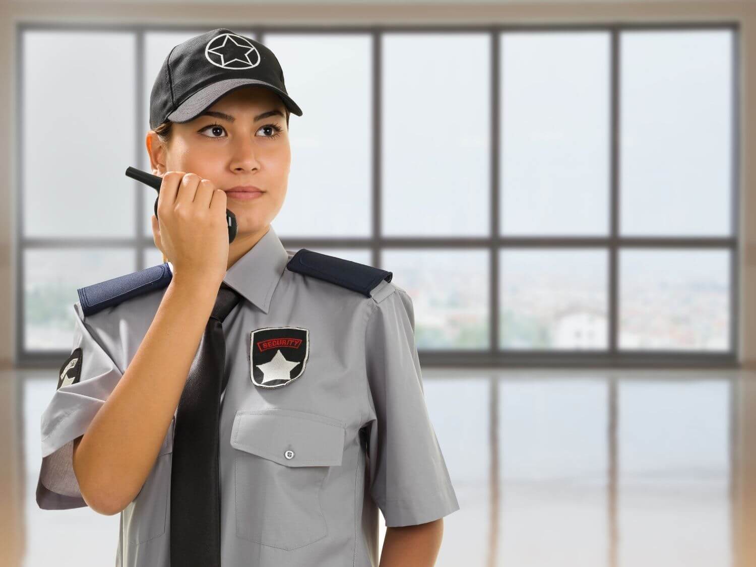 A lady security officer talking into a walkie talkie