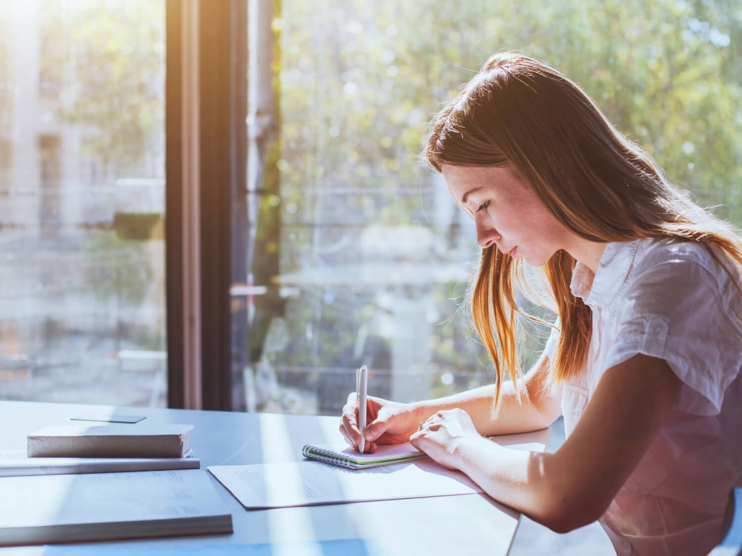 A teenage girl sitting at a desk revising.