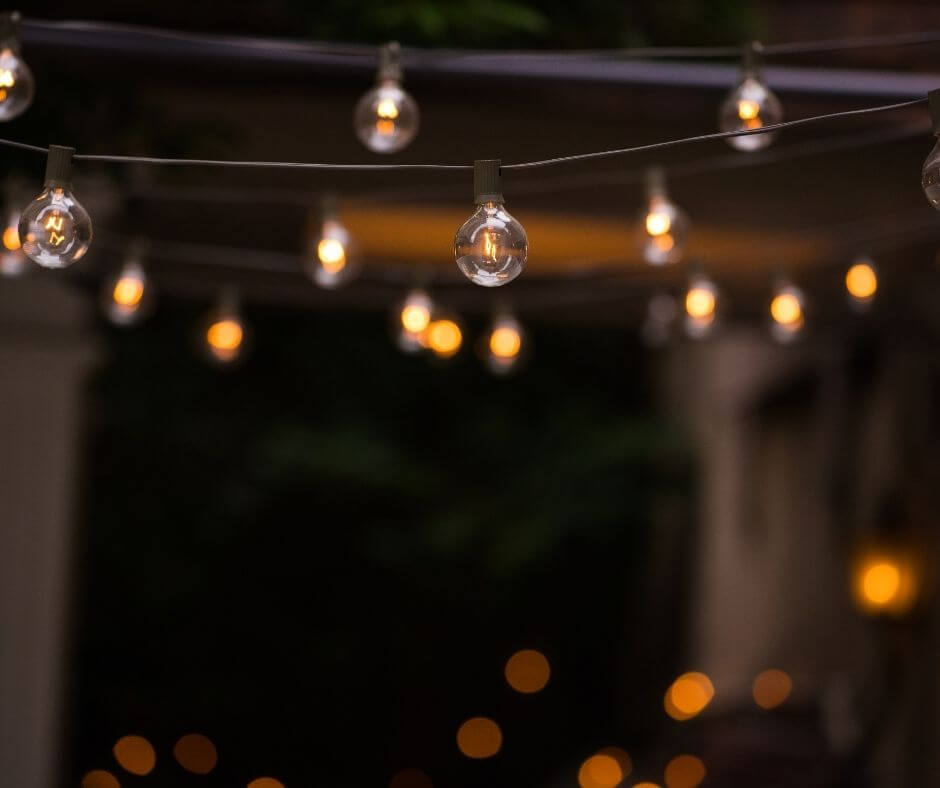 Festoon string lights hanging from a pergola.