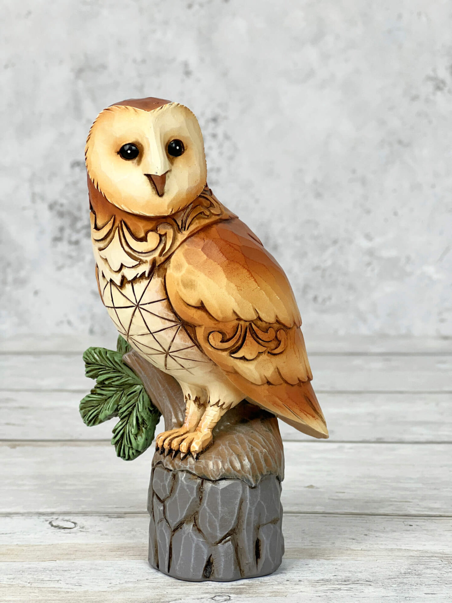 A barn owl figurine sat on a tree trunk