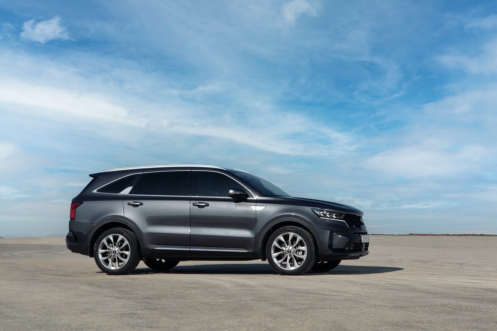 A dark grey Kia Sorento SUV parked on a sandy beach