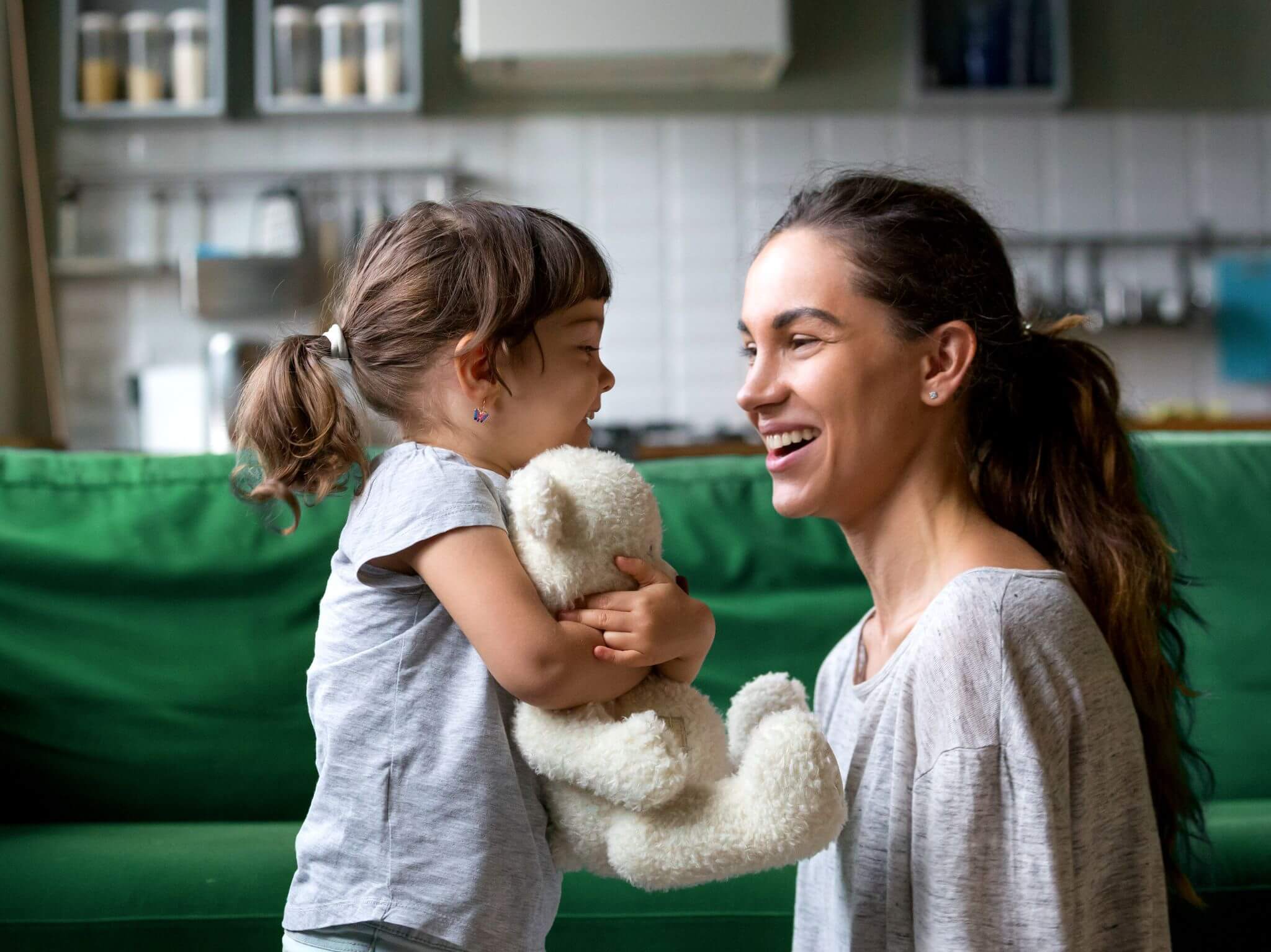 A mum on her knees chatting to her toddler daughter.