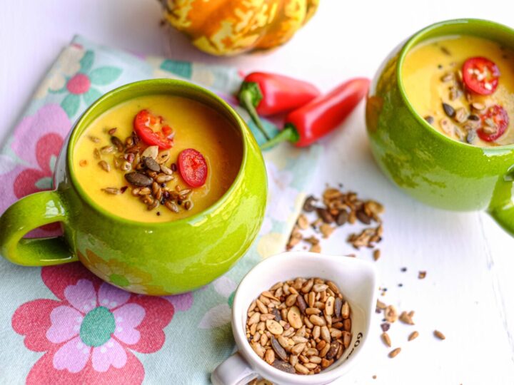 Homemade pumpkin soup in green soup mugs.