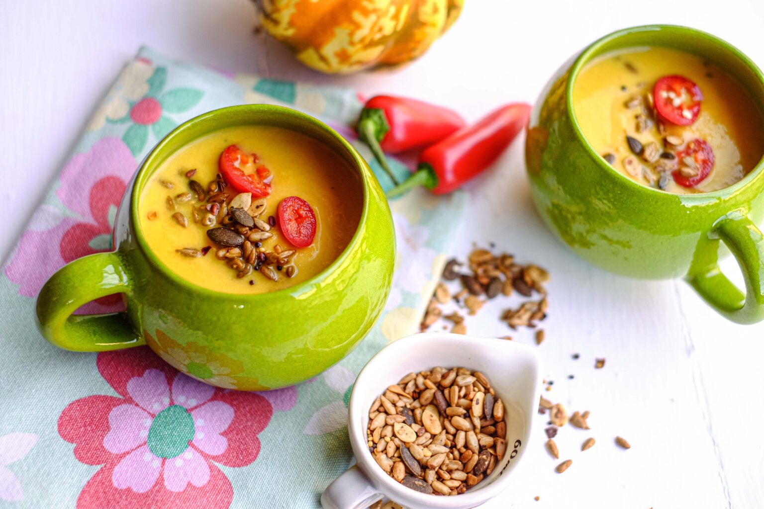 Homemade pumpkin soup in green soup mugs.