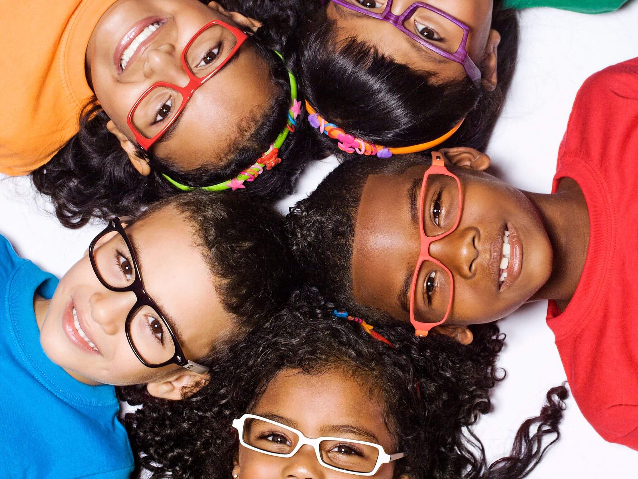 Children's faces in a cirle. They are all wearing different coloured glasses.