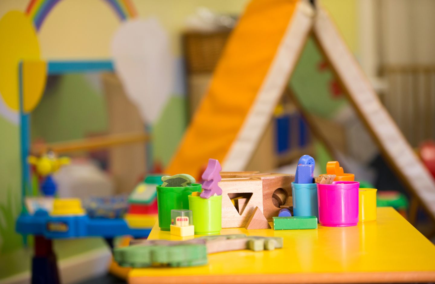A nursery table with a selection of colourful wooden toys.