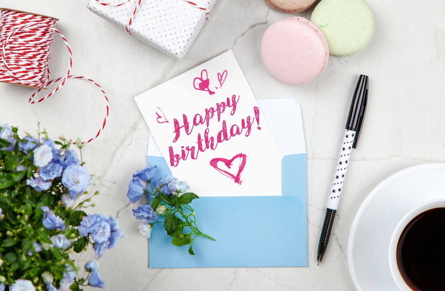 A desk top with a birthday card and flowers.