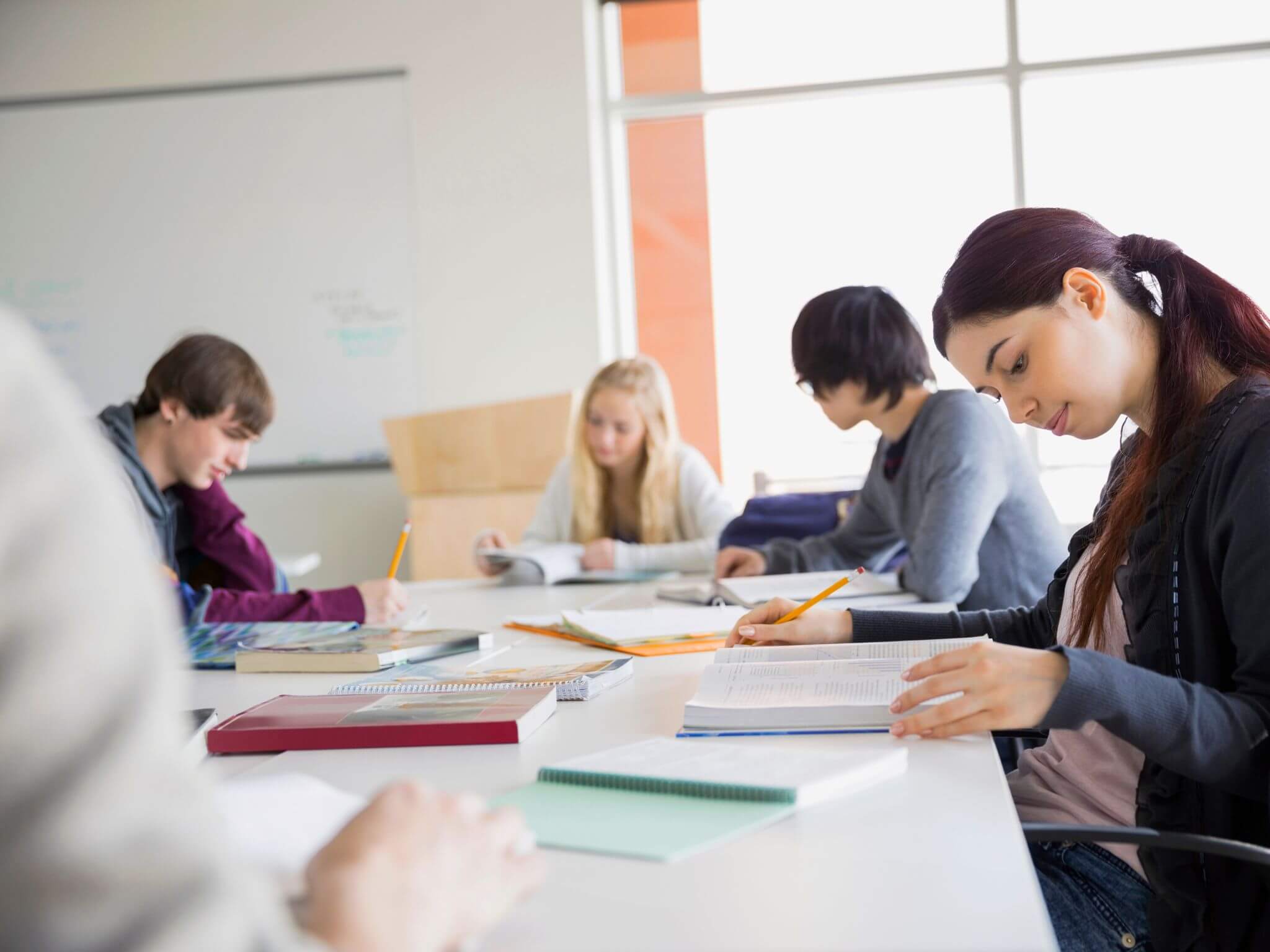 Older children studying around a class desk